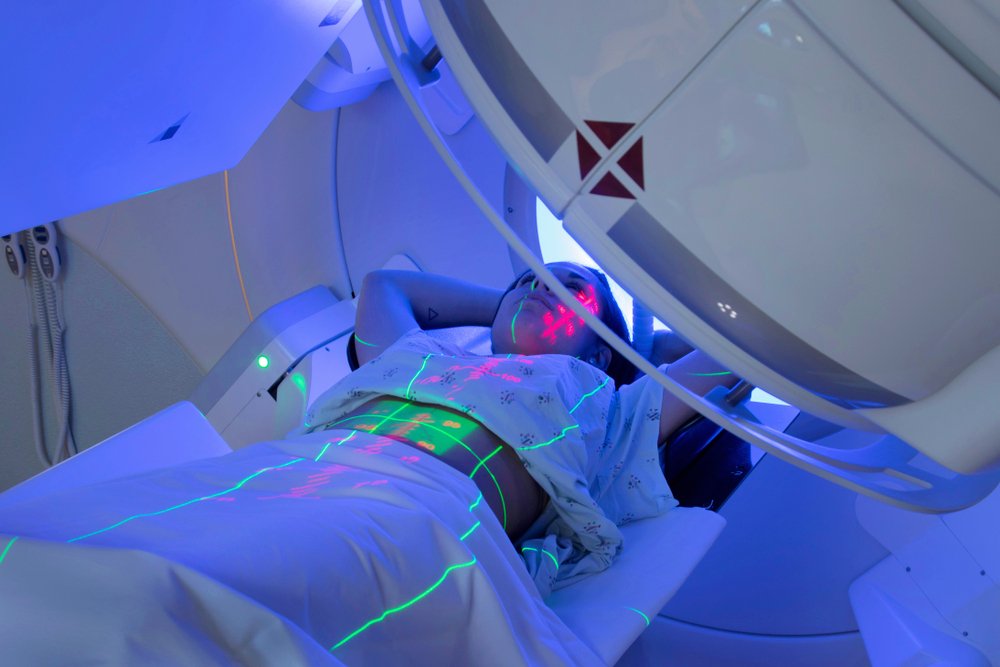 Paciente recebendo tratamento de radioterapia, simbolizando a luta contra o câncer e a importância da radioterapia sustentável.